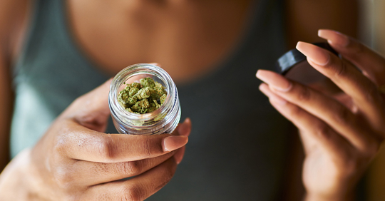 woman opening bottle of legal marijuana