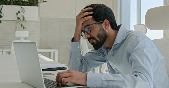 Frustrated businessman looking at his laptop